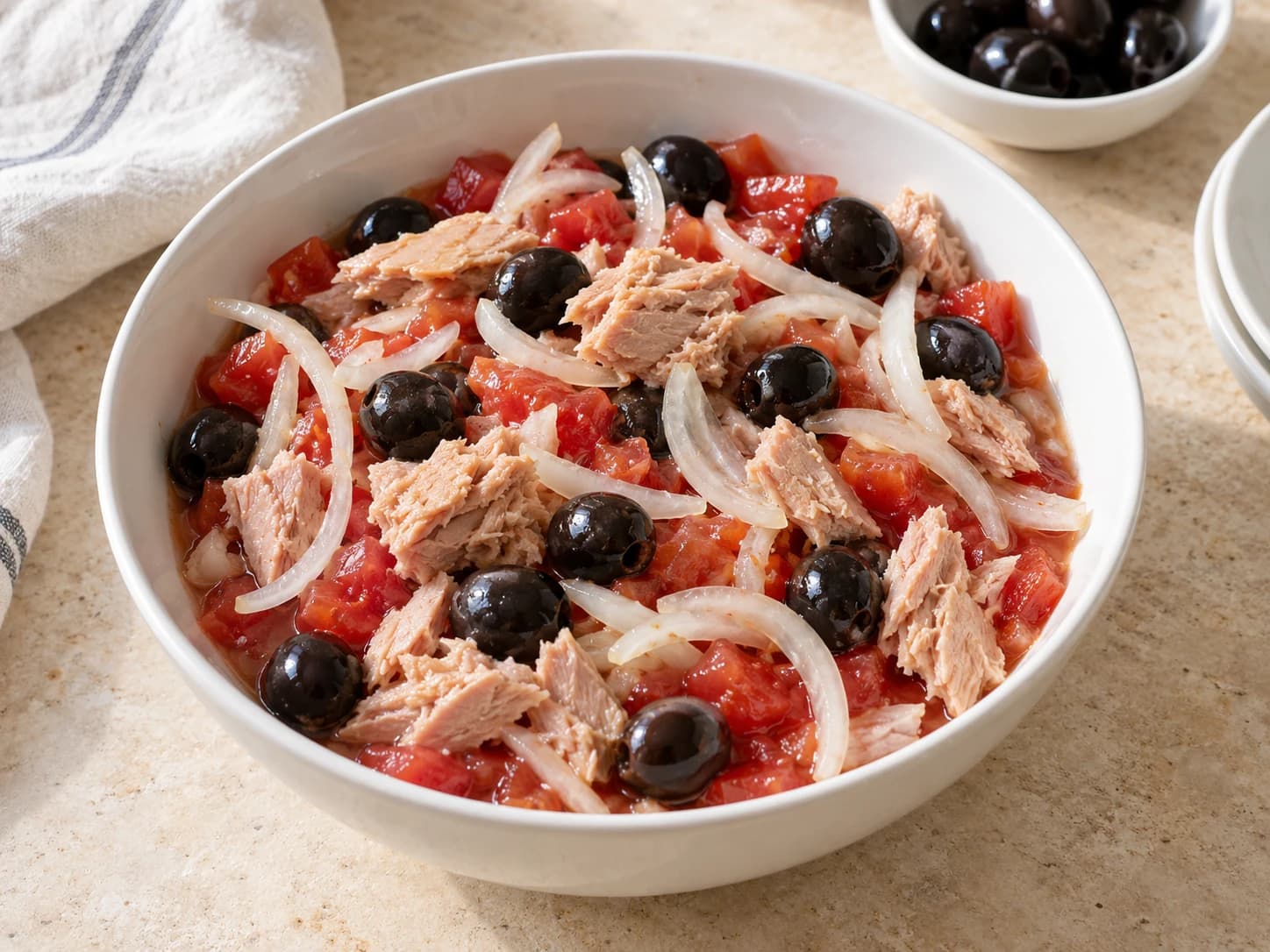 Drained tuna and black olives added to the tomatoes.